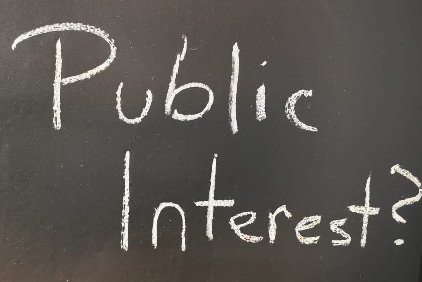 Blackboard with the words "Public Interest?" written on it
